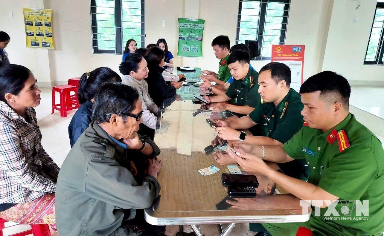 Cán bộ, lực lượng Công an, Quân đội và đoàn viên thanh niên xã Hướng Phùng nhiệt tình hướng dẫn người dân cài đặt các ứng dụng, thao tác kỹ năng số. (Ảnh: Võ Dung/TTXVN)